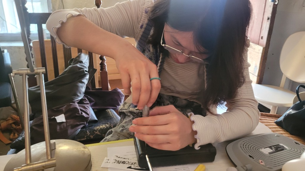 案头用螺丝刀拆解黑色电子外壳