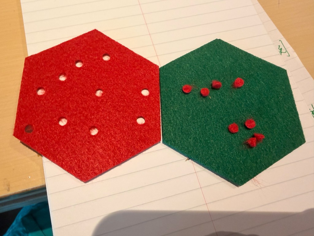 横线笔记本上的红绿毛毡六边形与圆孔碎片