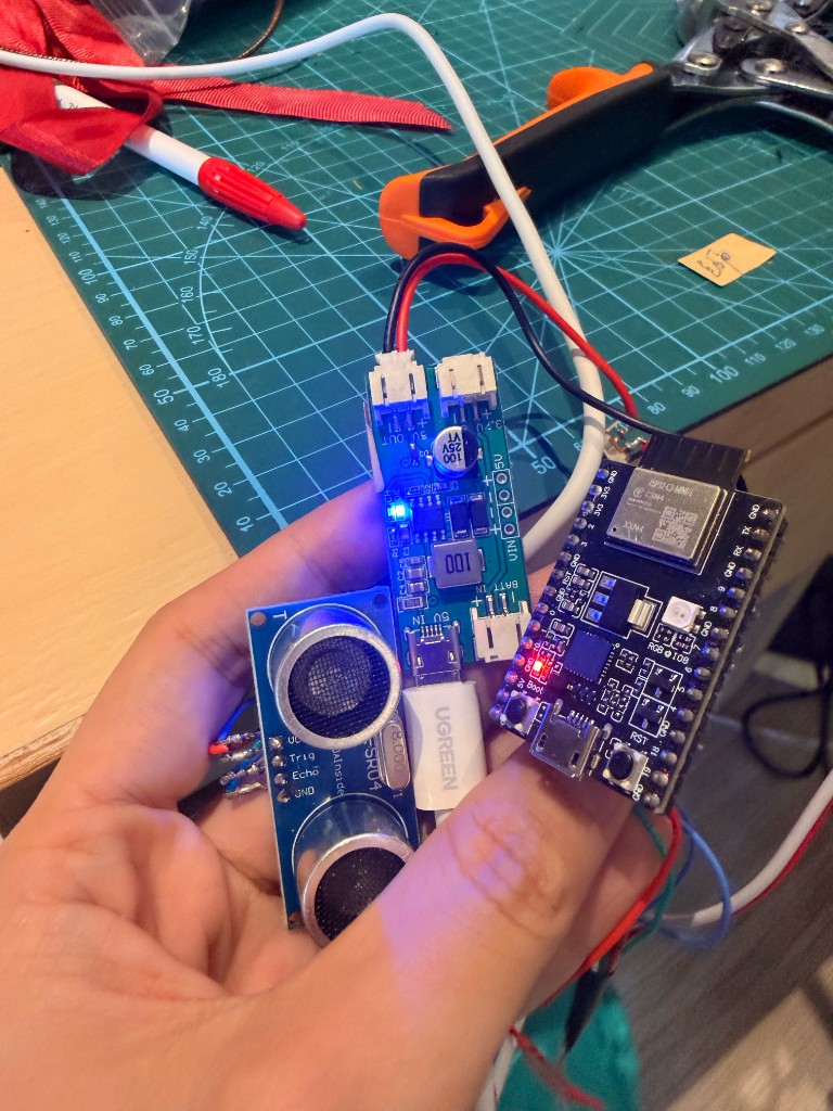 人形台架局部：格纹布、灯带、开发板与红绿毛毡片